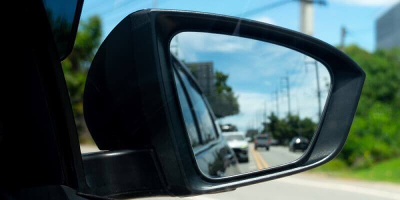 Wing mirror with cars blurred behind
