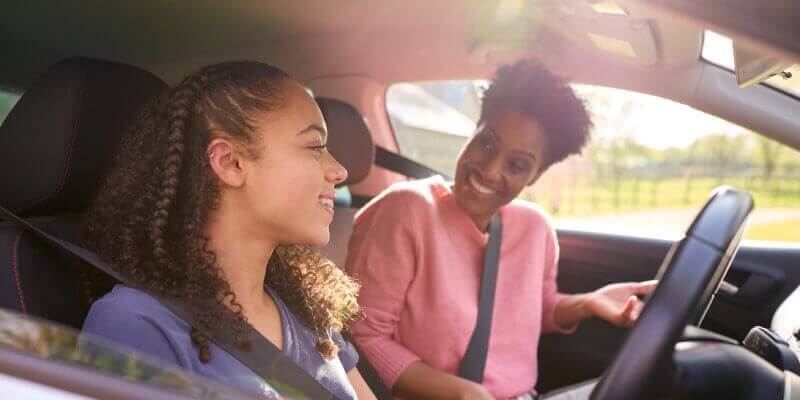 Women smiling at each other in car