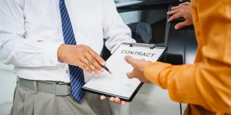 Person holding a contract and pen offering it to someone else