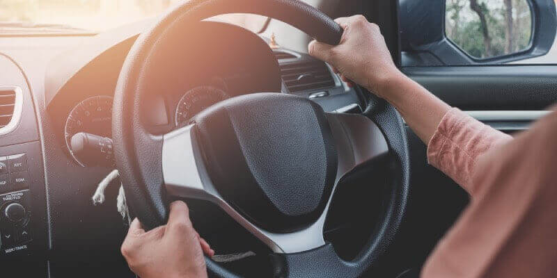 Both hands gripping the steering wheel