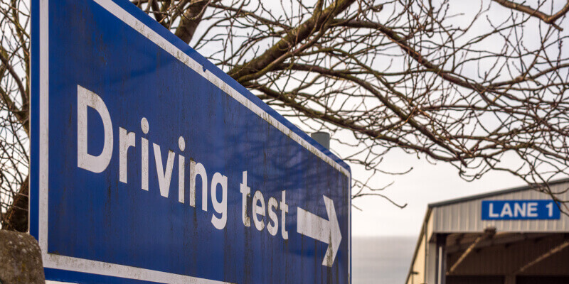Blue sign with the words 'driving test' and an arrow